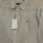 Beige shirt with Polo Ralph Lauren logo on a hanger against a beige background