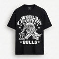 A black short-sleeve t-shirt with a white graphic print on the front. The graphic features a bull mascot, the text 'WORLD CHAMPIONS', '1996', 'BACK BACK', and 'BULLS' surrounded by stars.
