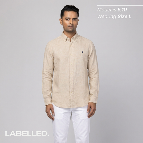 Man wearing a vintage Ralph Lauren beige shirt with a logo on a gray background